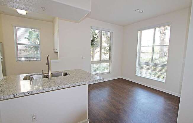 A kitchen with granite countertops and a sink at The Kitt at Warner Center Apartments, Woodland Hills, CA, 91303