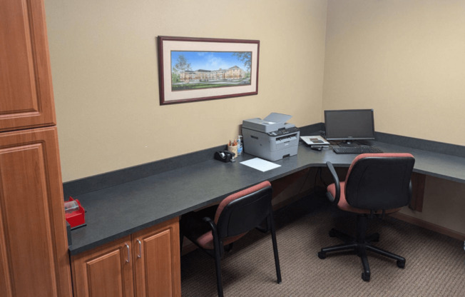 a desk with a computer and a printer on it