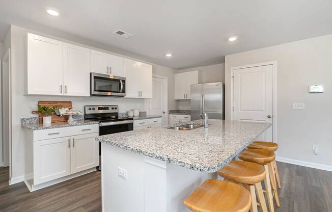 a kitchen with white cabinets and a granite counter top