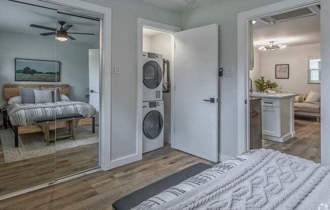 A bedroom with a washer and dryer in the doorway.