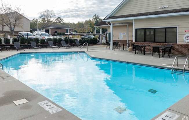 A swimming pool with a building in the background.