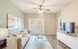 a living room with a couch and a ceiling fan