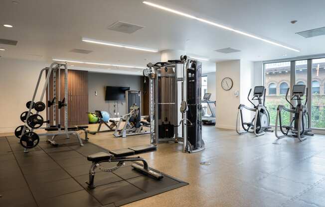 a gym with weights and cardio equipment in a building