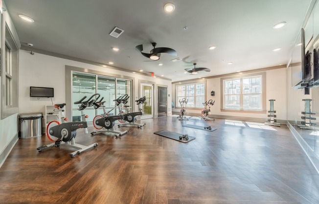 a home gym with exercise machines and a tv on the wall