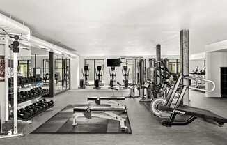 A black and white photo of a gym with a variety of equipment.