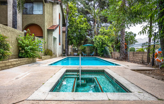 the pool is in front of a house with a swimming pool