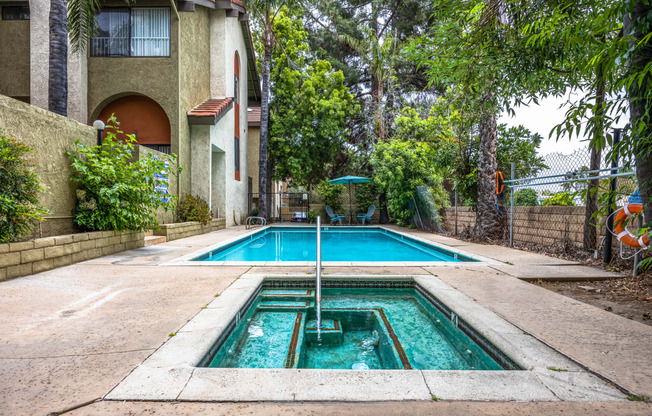 the pool is in front of a house with a swimming pool