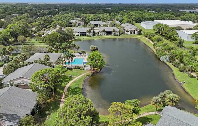 A bird's eye view of a residential area with a lake and houses.