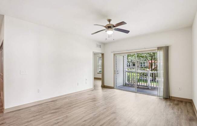 Royal Palm living room with a ceiling fan and sliding glass doors that lead to the patio at Oakleaf Plantation Apartments in Jacksonville, FL