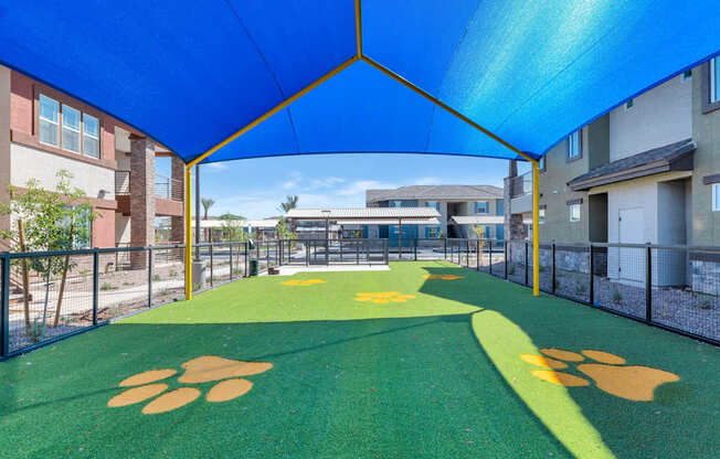 A playground with a green surface and yellow paw prints.