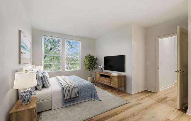 A bedroom with a bed, nightstand, and a television.