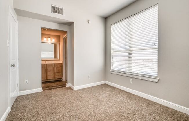 a bedroom with a large window and carpet