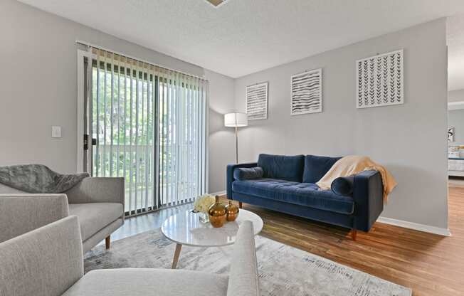 a living room with a blue couch and a glass coffee table