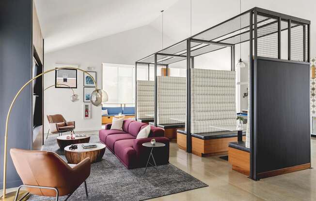 A living room with a purple couch and a black and white striped wall.