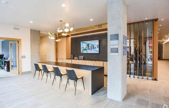 A reception area with a row of chairs and a television on the wall.
