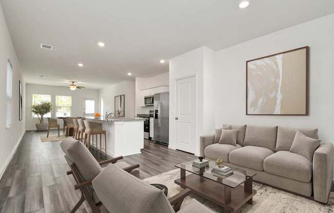 A modern living room with a grey sofa, wooden chairs, and a coffee table.