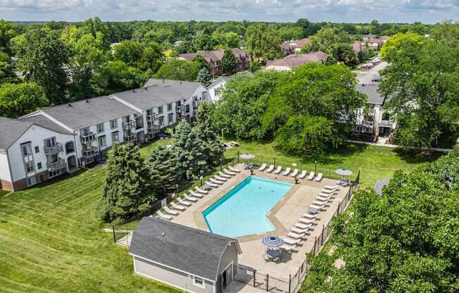 An aerial view of a resort with a swimming pool and lounge chairs