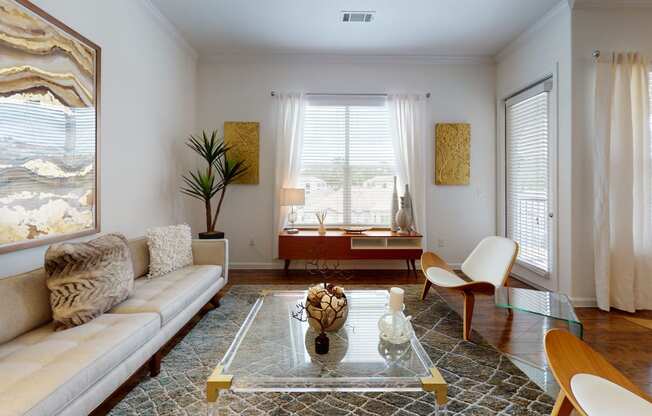 a living room with white walls and a glass coffee table
