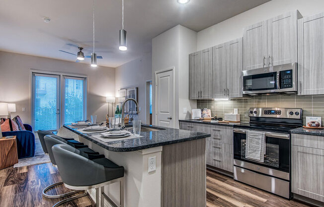 Granite counter tops, stainless appliance package, medium brown cabinets, plank wood-style flooring, island seating, abundant cabinet and pantry space