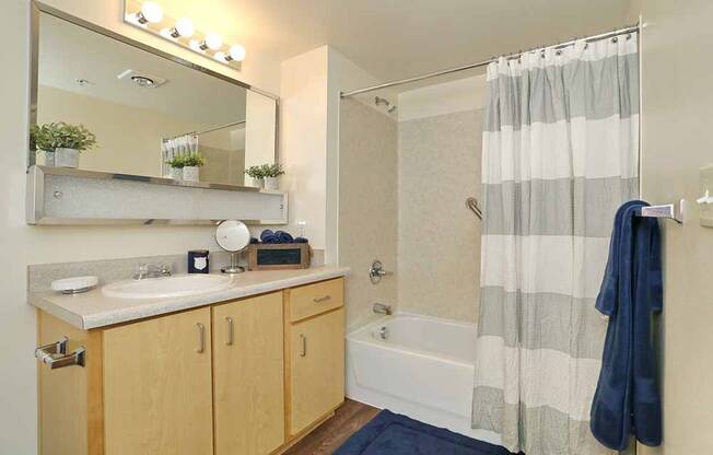 Apartments for Rent in Everett-Vintage At Everett Apartments Bathroom With Square Tile And Tub And Vanity Lighting