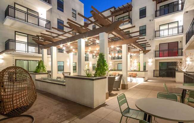 A patio with a table and chairs is surrounded by apartment buildings.