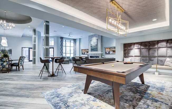 A billiard table is in the middle of a room with a blue carpet.