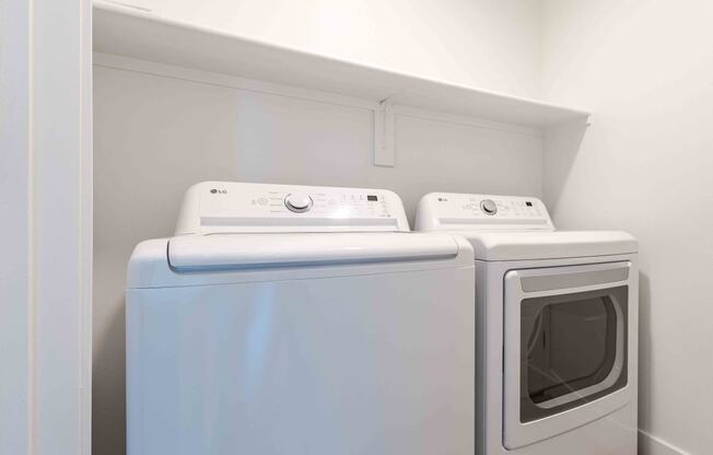 a washer and dryer in a laundry room with white walls