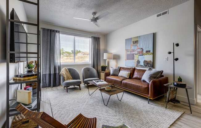 Living room with rug, designed furnishing, ceiling fan, and window