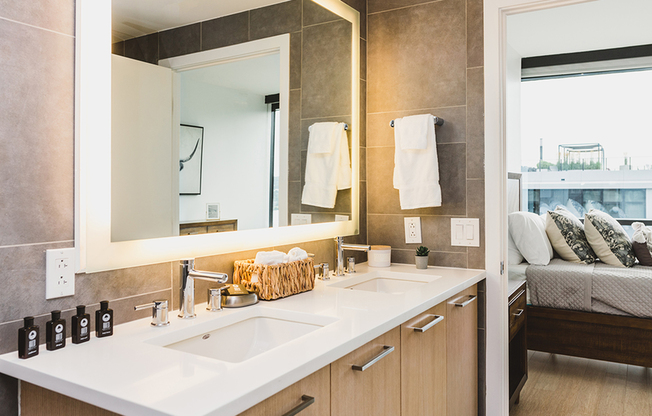 Spa-like bathroom featuring dual vanity and LED back lit mirror