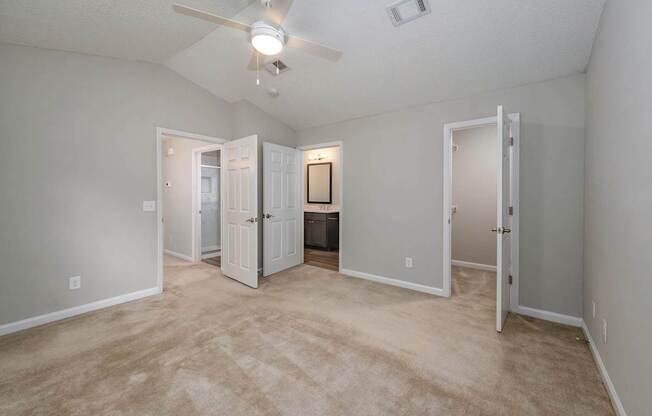 A room with a ceiling fan and carpeted floor.
