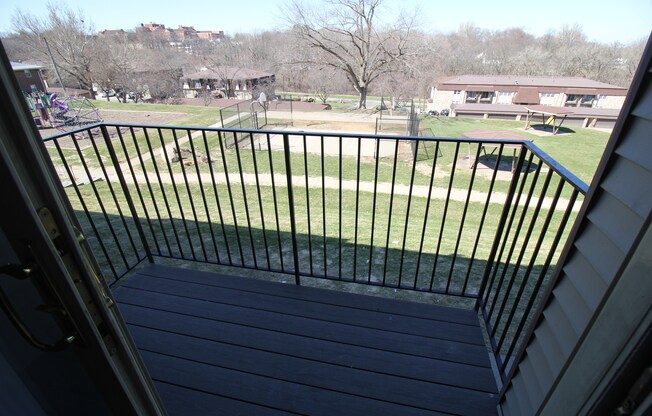 a balcony with a fence and a park in the background