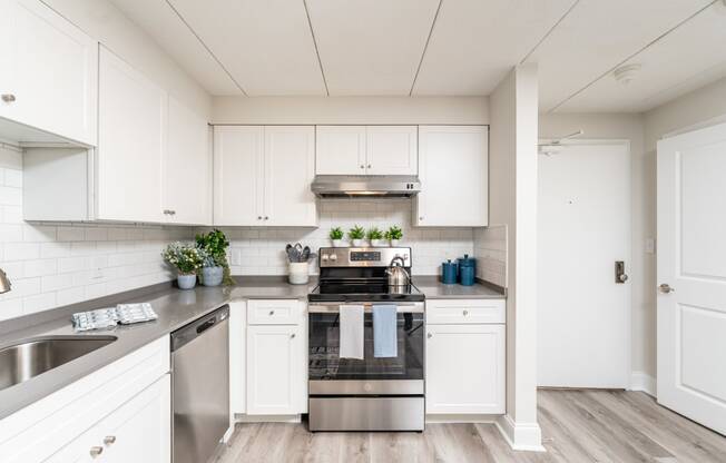 a kitchen with white cabinets and stainless steel appliances