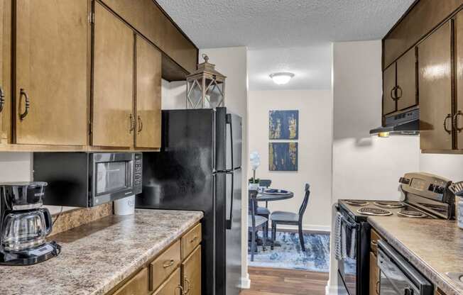 full kitchen with granite counters and appliances and a dining room with a table and chairs