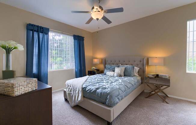 A bedroom with a bed, nightstand, and window.