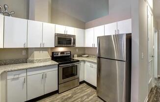 a kitchen with stainless steel appliances and white cabinets