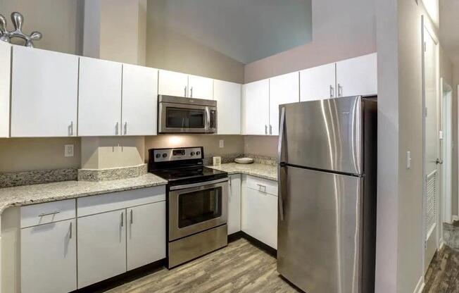 a kitchen with stainless steel appliances and white cabinets