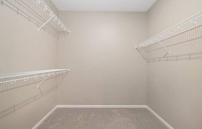 Empty room with white shelves and carpeted floor.