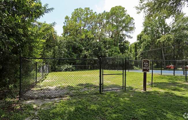 A sign on a fence in a grassy area.