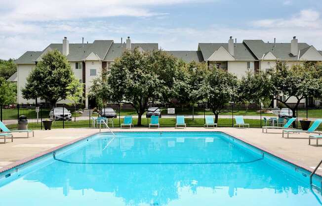 A swimming pool in front of a row of houses.