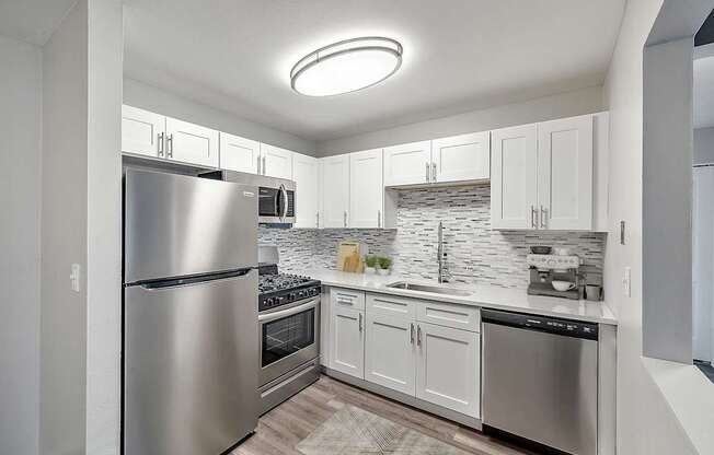 A modern kitchen with stainless steel appliances and white cabinets.