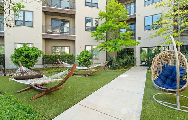 A modern outdoor patio area with a hammock and a swing.
