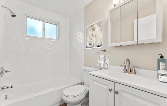 a white bathroom with a sink and a toilet