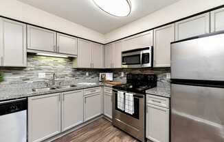 a kitchen with white cabinets and stainless steel appliances