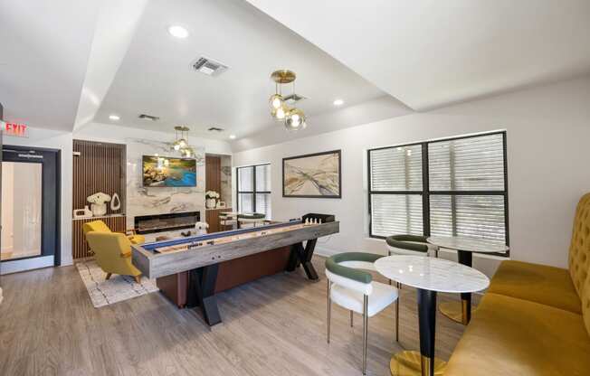 a game room with a pool table and chairs