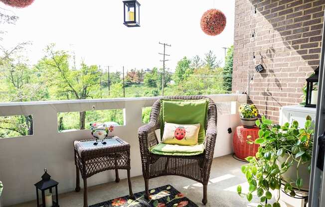 A balcony with a chair and a table with a vase on it.