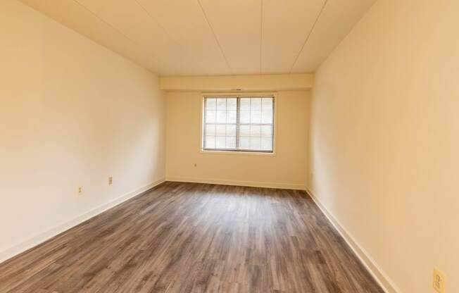 a bedroom with hardwood floors and yellow walls