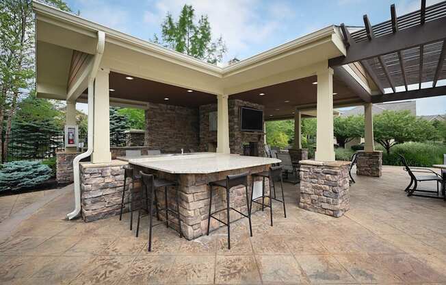 a covered patio with an outdoor kitchen and bar at Sovereign at Overland Park, Overland Park Kansas  