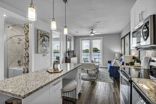 A modern kitchen with granite countertops and stainless steel appliances.