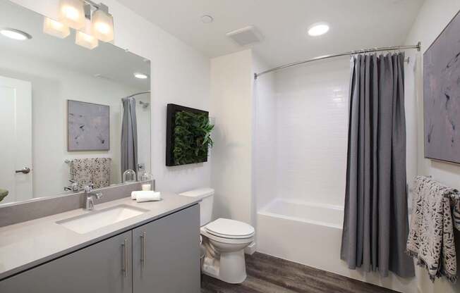 A bathroom with a toilet, sink, and shower.