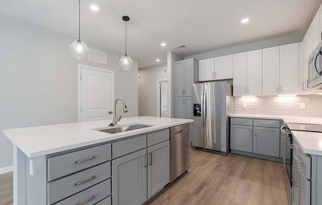 a kitchen with white cabinets and a stainless steel refrigerator